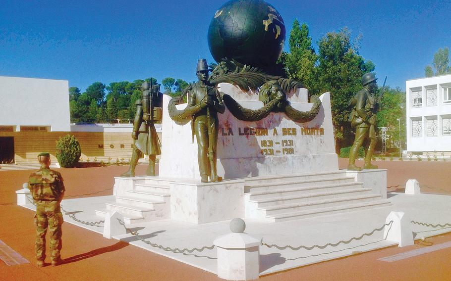 A legionnaire stands in front of the Foreign Legion's monument to the dead, on the parade ground at Aubagne, the unit's headquarters and its main recruitment base. The monument, which was originally built at the Legion's base in Algeria, was dismantled and rebuilt in Aubagne in the 1960s after the end of French colonial rule in that North African nation.