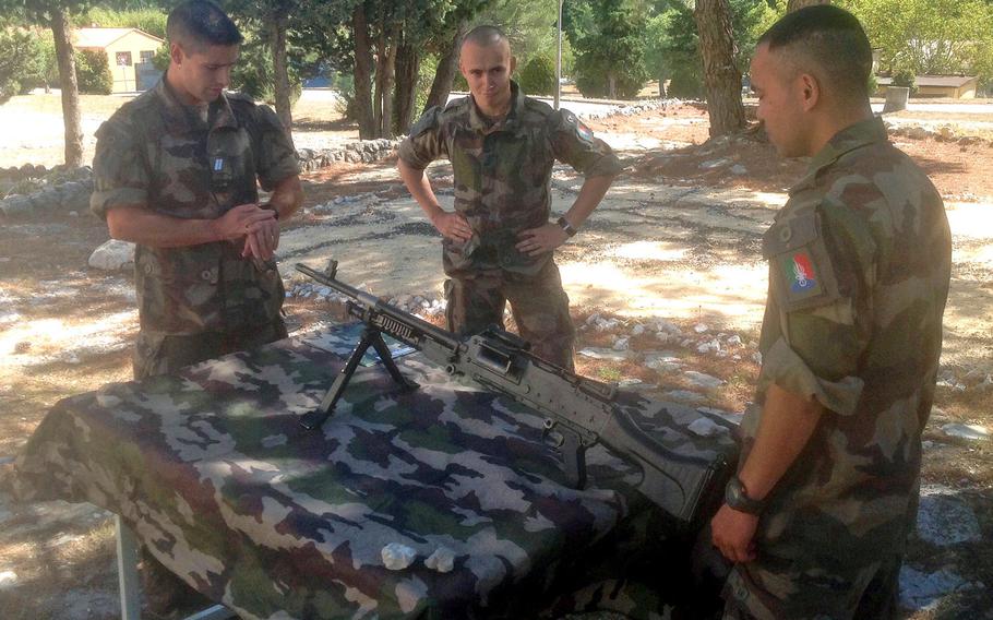 A group of legionnaires from the 1st Foreign Cavalry Regiment clean a machine gun at the unit's home base at Camp de Carpiagne on the Mediterranean coast. The regiment is armed with VAB wheeled armored personal carriers and AMX-10RC armored cars mounting a 105mm cannon.