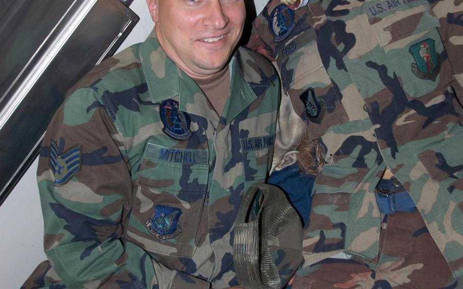 Then-Staff Sgt. Jerred Mitchell lies on the floor next to a masked dummy that was part of his squadron's Haunted Dungeon at Misawa Air Base, Japan in Oct. 2007.  Mitchell, now a master sergeant at  Ramstein Air Base, Germany, almost lost his pension due to being medically retired from the Air Force. 

