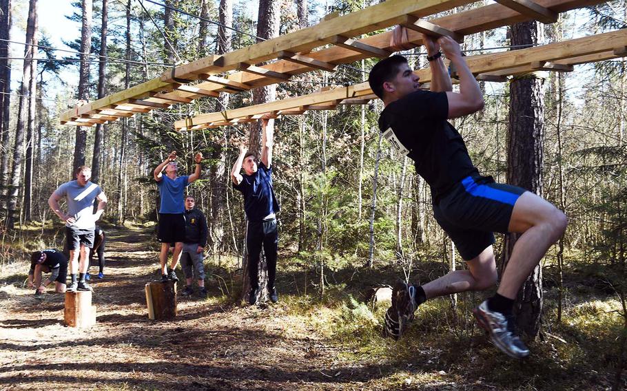 Runners maneuver through the monkey bars during the Rugged Terrain Obstacle Run, at Grafenwoehr, Germany, Saturday, April 7, 2018. 