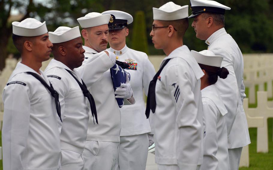 Sailors from the U.S. Naval Hospital Naples, Italy, finish folding the American flag during a memorial service for U.S. Naval Reserve Radioman 2nd Class Julius “Henry” Pieper at Normandy American Cemetery in Colleville-sur-Mer, France, Tuesday, June 19, 2018. Pieper was killed along with his twin brother, Ludwig, when their landing ship hit a mine on June 19, 1944. 



