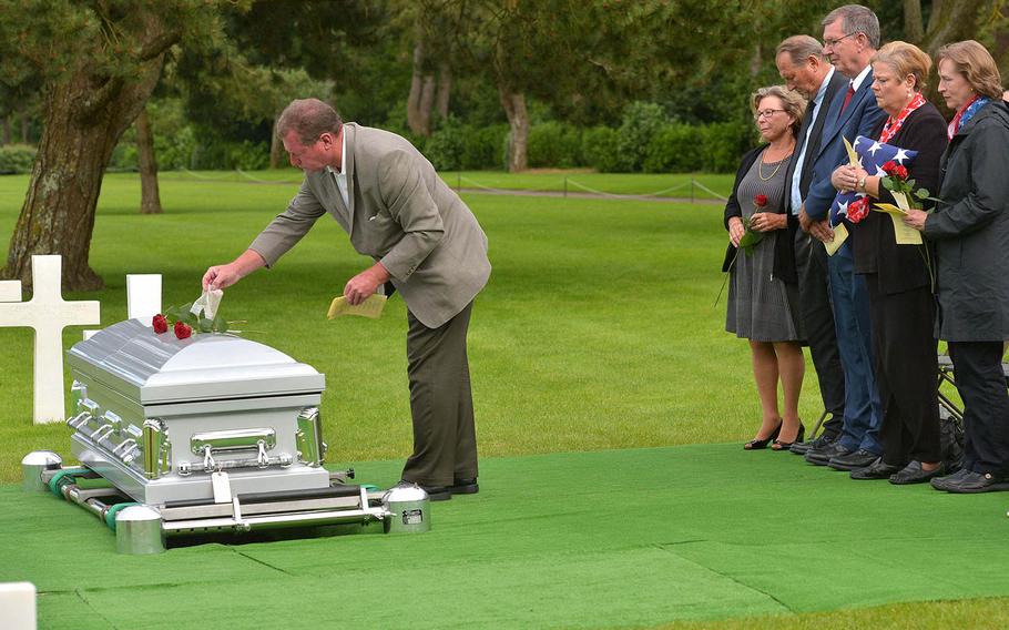 Fred Pieper, a nephew of Julius “Henry” Pieper, spreads dirt from Pieper's hometown on his coffin as other family members watch, during a memorial ceremony at Normandy American Cemetery in Colleville-sur-Mer, France, Tuesday, June 19, 2018. 




