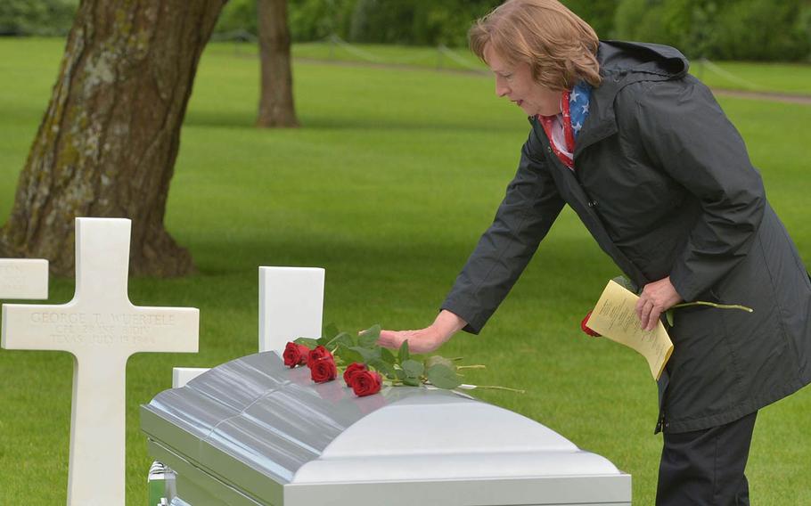 Julius “Henry” Pieper's niece Susan Lawrence places a rose on his coffin at the conclusion of a memorial service for Pieper at Normandy American Cemetery in Colleville-sur-Mer, France, Tuesday, June 19, 2018. 