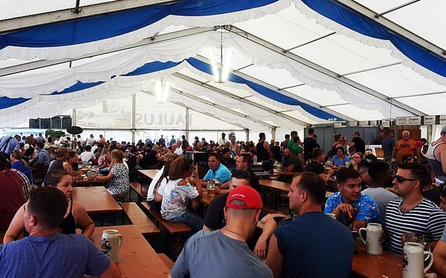 Germans and Americans drink beer under a German-style beer tent at the German-American Volksfest at Grafenwoehr, Germany, Friday, Aug. 3, 2018. 