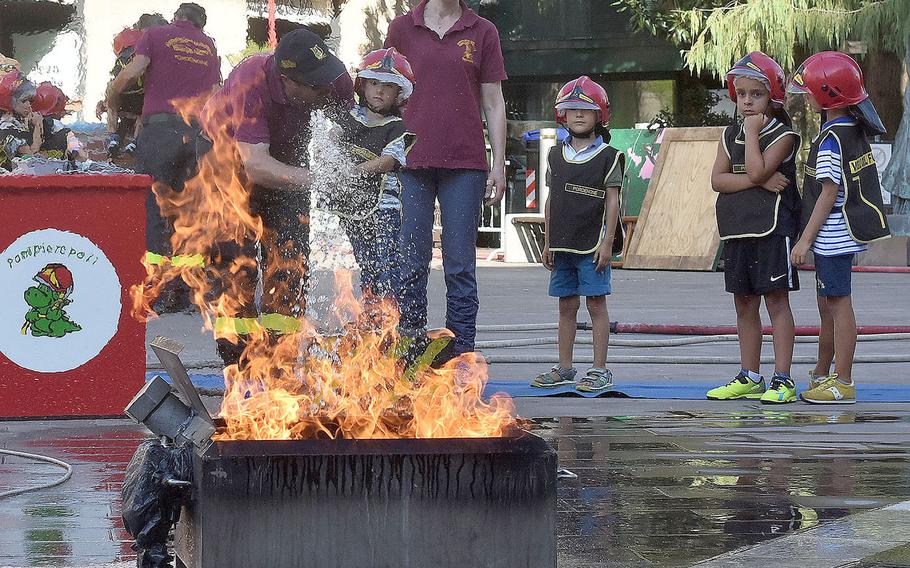 Firefighters with the Vigili del Fuoco of Pordenone help a child put out a mock fire during the 17th annual Italian-American Frienship Festival that took place Saturday, Sept. 8, 2018, in the city of Pordenone, Italy. 