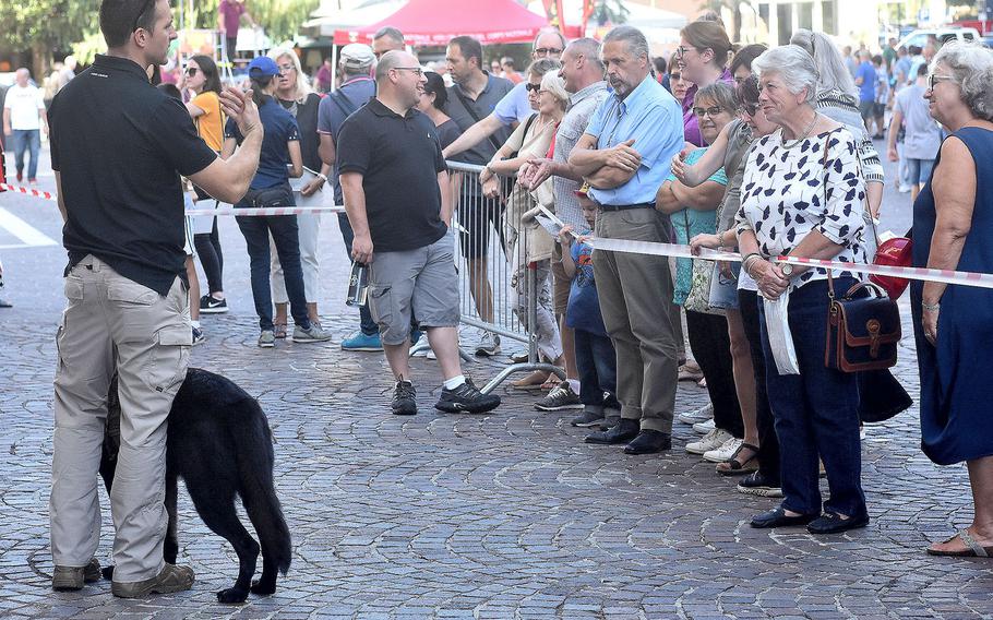 An member of the canine unit of the 31st Fighter Wing's security forces, Aviano Air Base, Italy, addresses a group of people during a military working dog demonstration that was held at the XX Settembre piazza, Pordenone. The demonstration was part of the 17th annual Italian-American Friendship Festival that took place Saturday, Sept. 8, 2018, in the city of Pordenone. 