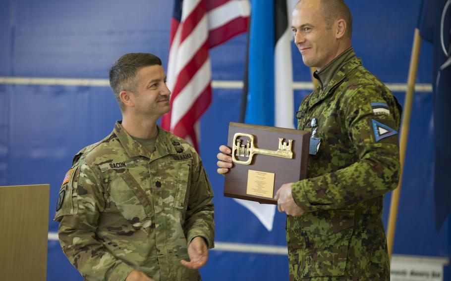 Lt. Col. John Bacon, U.S. Army Corps of Engineers division deputy commander, hands the ceremonial key to the newly completed aircraft maintenance facility to Lt. Col Ülar Lõhmus, Estonia’s Amari Air Base commander, Oct. 16, 2018. 
