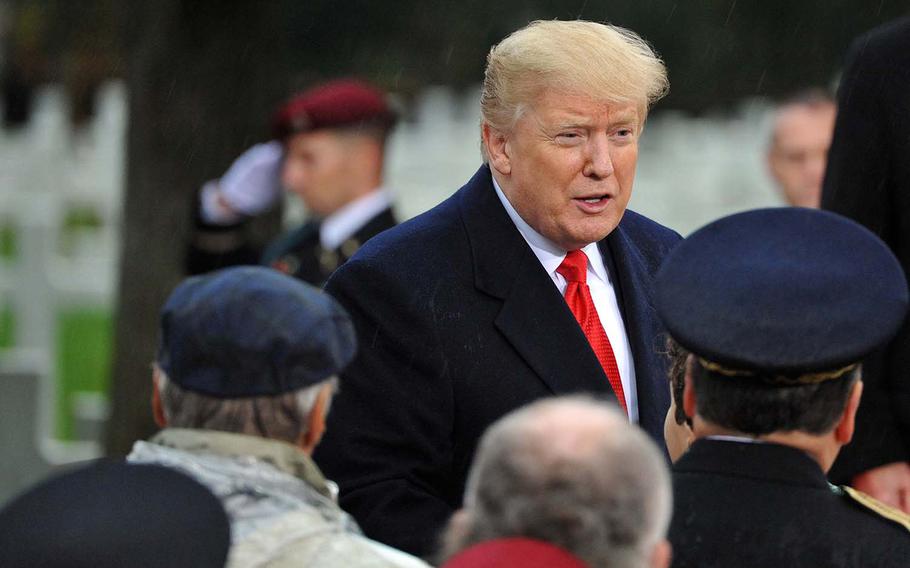President Donald Trump speaks to other dignitaries after speaking at the World War I armistice centennial ceremony, at Suresnes American Cemetery on the outskirts of Paris, Sunday, Nov. 11, 2018.