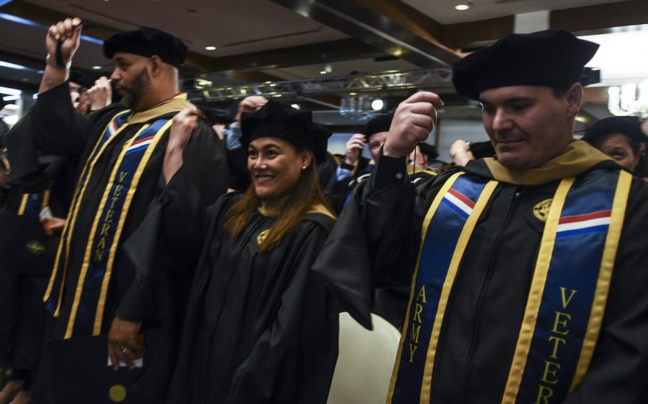 Graduates move their cap tassels from right to left after receiving their diplomas at the UMUC Europe commencement on Saturday, May 4, 2019, at Ramstein Air Base, Germany.