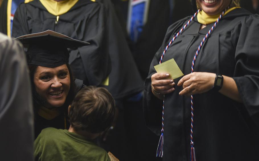 Marisa Niesen crouches down for a hug from her son while waiting for the UMUC Europe commencement ceremony to begin on Saturday, May 4, 2019, at Ramstein Air Base, Germany.