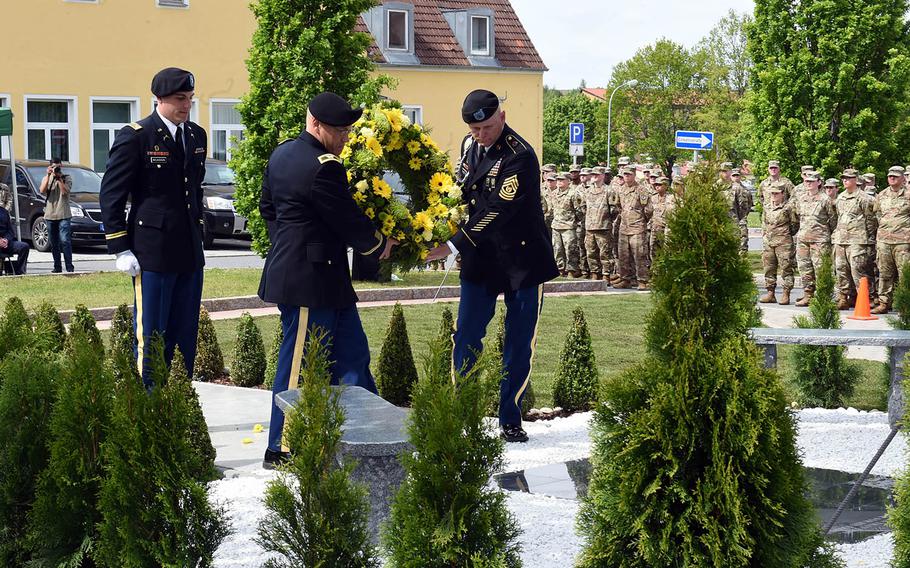 Sgt. Maj. Ted Pearson and Col. Glenn Schmick, with the 18th Military Police Brigade, carry a wreath to the newly rededicated memorial to fallen soldiers from their brigade, Thursday, May 23, 2019, at Vilseck, Germany. 
