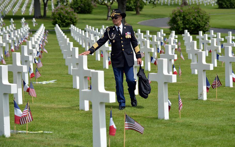 Retired Sgt. 1st Class Tom Favia touches a cross following a Memorial Day ceremony at Lorraine American Cemetery in St. Avold, France, Sunday, May 26, 2019. Favia, who lives nearby in Germany, says he tries to come to the ceremony every year. With 10,489 graves, the cemetery is the largest World War II U.S. World War II cemetery in Europe.