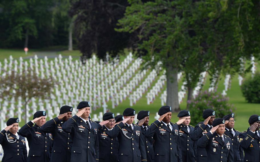 Soldiers of the 2nd Cavalry Regiment out of Vilseck, Germany, salute during the playing of the U.S. and French national anthems during the Memorial Day ceremony at Lorraine American Cemetery in St. Avold, France, Sunday, May 26, 2019.