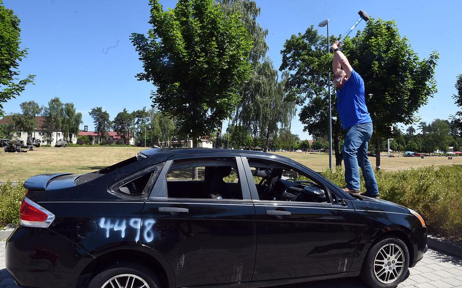 Sgt. Maj. Micheal Sutterfield, the sergeant major of U.S. Army Garrison Bavaria, hits a Ford Focus with a sledgehammer during an Independence Day celebration at Grafenwoehr, Germany, Thursday, July 4, 2019. 
