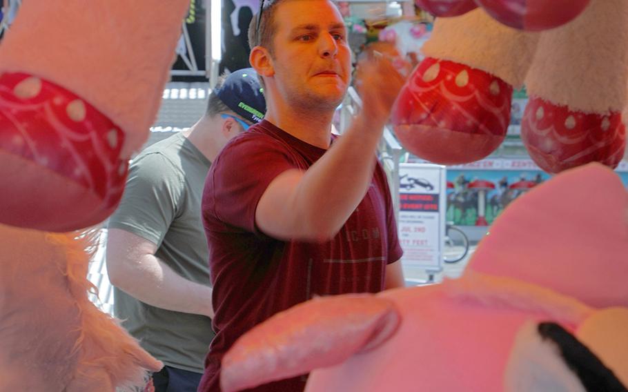 Tech. Sgt. Michael "Teddy" Graham with the 48th Component Maintenance Squadron shoots darts to try to win a stuffed animal Thursday, July 4, 2019, at the Fourth of July Liberty Fest at RAF Lakenheath, England.