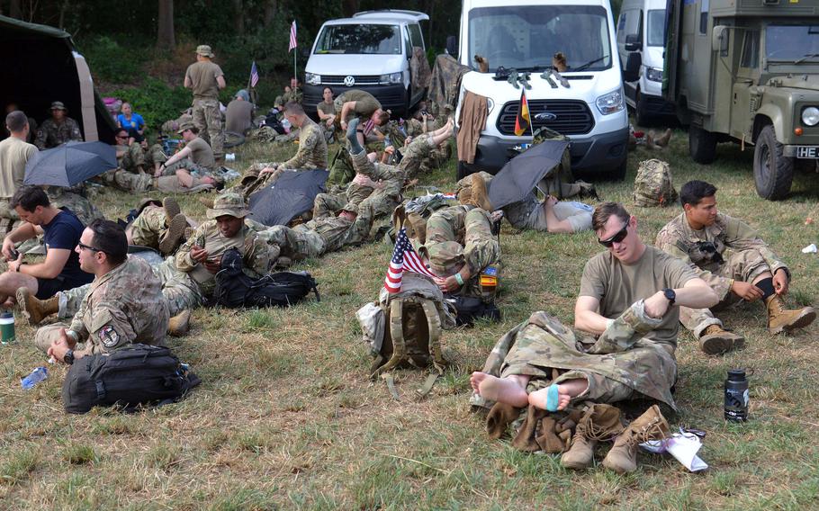 American servicemembers take a break and rest their feet in Milsbeek, Netherlands, on the third day of the Nijmegen Four Days Marches, Thursday, July 18, 2019.