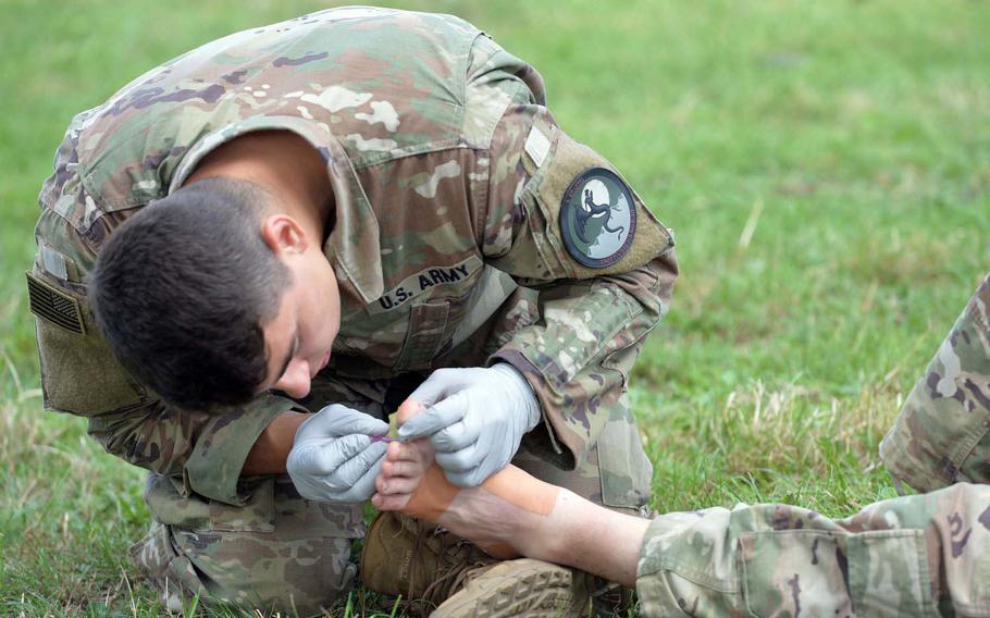 Spc. Andrew Zaranko, a medic with Troop C, Regimental Support Squadron, 2nd Cavalry Regiment out of Vilseck, Germany, works on a soldier's foot at a rest area in Gassel, Netherlands, on the final day of the Nijmegen Four Days Marches, Friday, July 19, 2019.