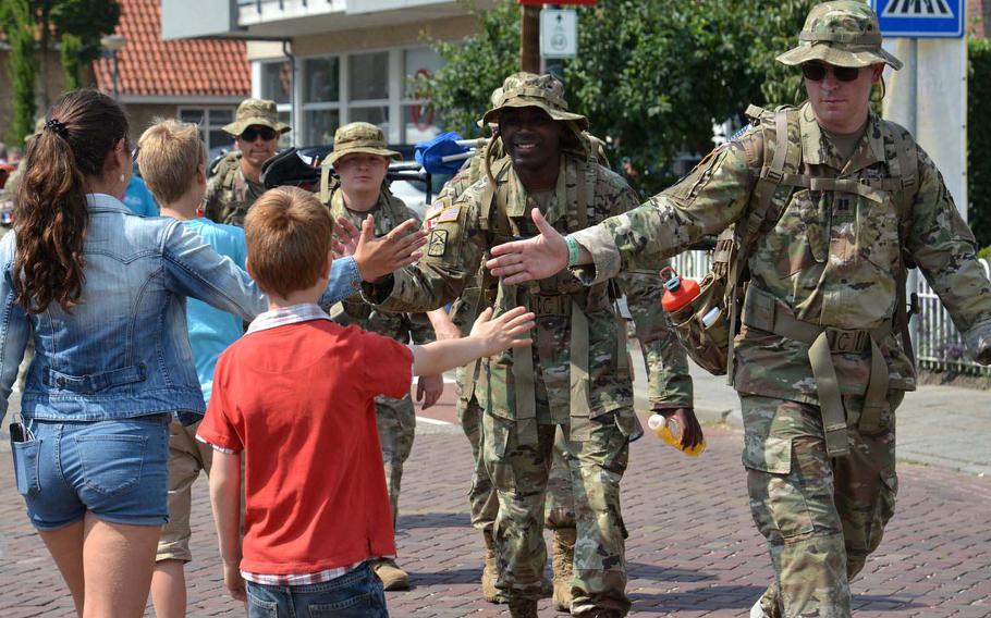 U.S. servicemembers are greeted with hand-slaps, high-fives and fist-bumps on the streets of Beers, Netherlands, Friday, July 19, 2019, during the Nijmegen Four Days Marches.