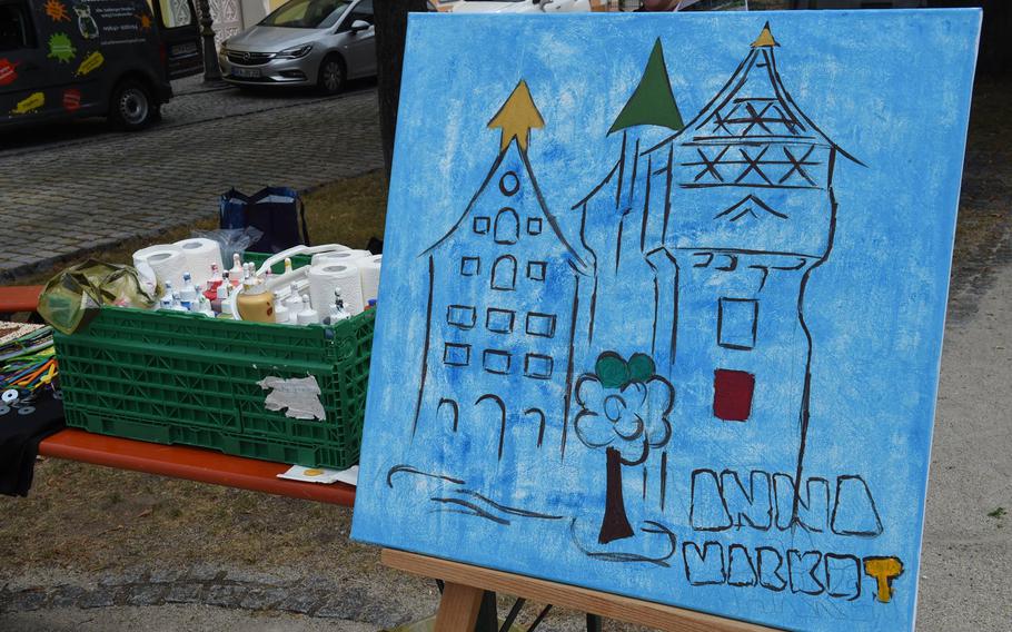 A painting of the namesake water tower of Tower Barracks and the Grafenwoehr Rathaus on display at a market in Grafenwoehr, Germany, on Sunday, July 28, 2019. 
