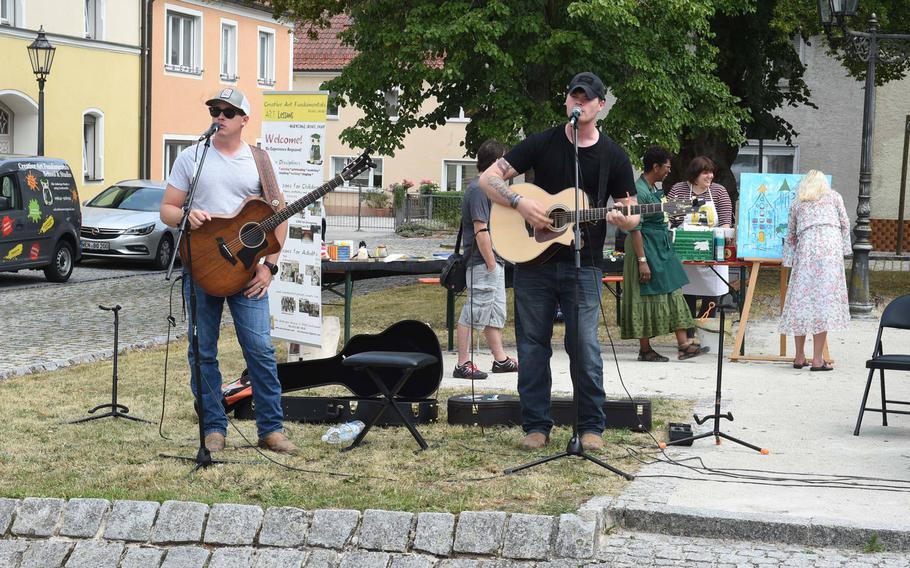 Staff Sgt. Austin Freeman, left, and Sgt. Jeremy Dahl, both mortarmen with the Army's 2nd Cavalry Regiment in Vilseck, Germany, play guitar and sing at a market in Grafenwoehr, Germany, Sunday, July 28, 2019. 


