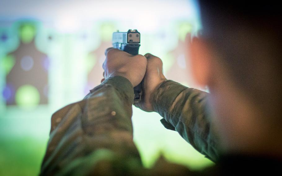 A soldier aims a pistol during training on the Army's Squad Advanced Marksmanship Trainer at Fort Drum, N.Y., in March 2019. The Army is revamping how soldiers train with small arm weaponry with tougher marksmanship tests.