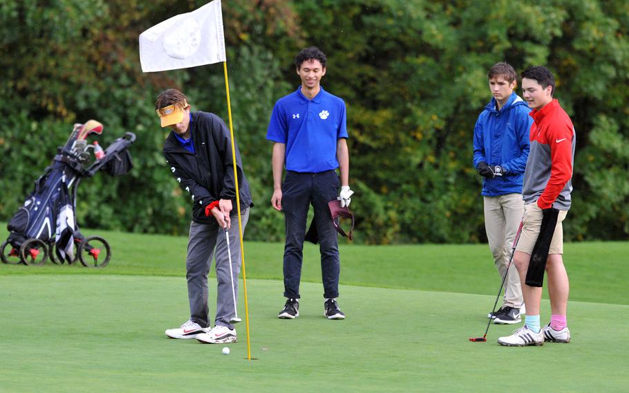Ramstein's Matt Miller putts on the day's final hole at the DODEA-Europe high school golf championships in Wiesbaden, Germany, as teammate Chris Angeles, Stuttgart's Jonathan Keathley and Kaiserslautern's Mathias Perrin watch. The tourney wraps up tomorrow, Oct. 10 at Rheinblick Golf Club.










