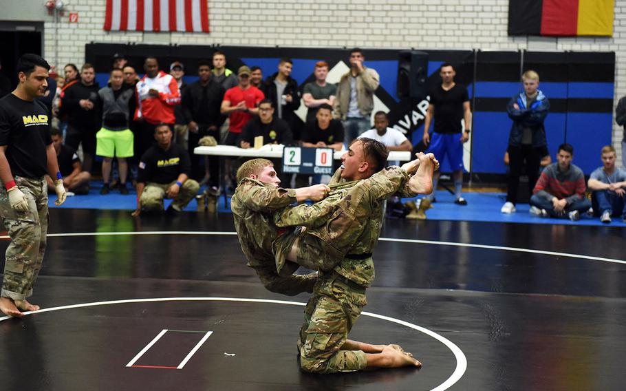 Spc. Dustin Payne, left, sets up a triangle choke on Pfc. Allan Esser during the 2nd Cavalry Regiment Fight Night, Friday, Oct. 18, 2019, in Vilseck, Germany.