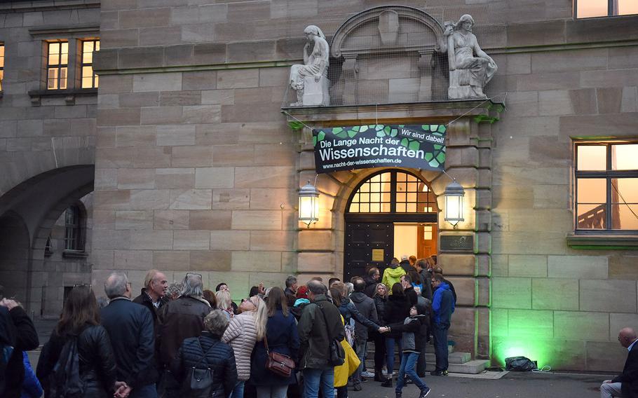 A line of people wait to enter the mock trials at the Courtroom 600 of the Nuremberg Palace of Justice, in Nuremberg, Germany, Saturday, Oct. 19, 2019.
