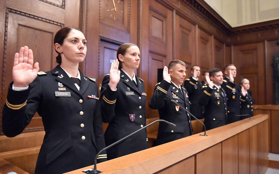 Jury members raise their right arms at the beginning of a mock trial at Courtroom 600 of the Nuremberg Palace of Justice, in Nuremberg, Germany, Saturday, Oct. 19, 2019. 
