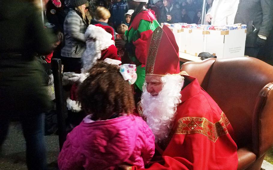 St. Nicholas talks to a little girl during the holiday tree lighting ceremony at Grafenwoehr, Germany, Tuesday, Dec. 3, 2019. 