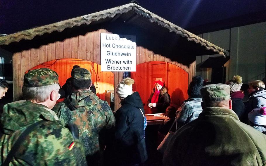 German and American soldiers and family members stand in line to get traditional German Christmas foods and drinks during the holiday tree lighting ceremony at Grafenwoehr, Germany, Tuesday, Dec. 3, 2019. 