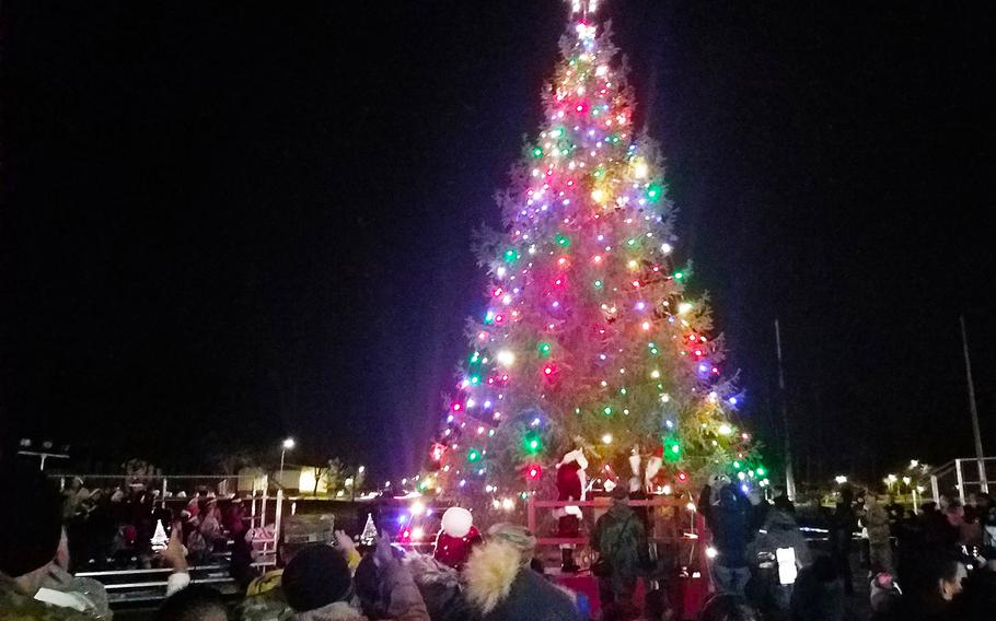 Crowds gather around the Christmas tree during the holiday tree lighting ceremony at Grafenwoehr, Germany, Tuesday, Dec. 3, 2019. 