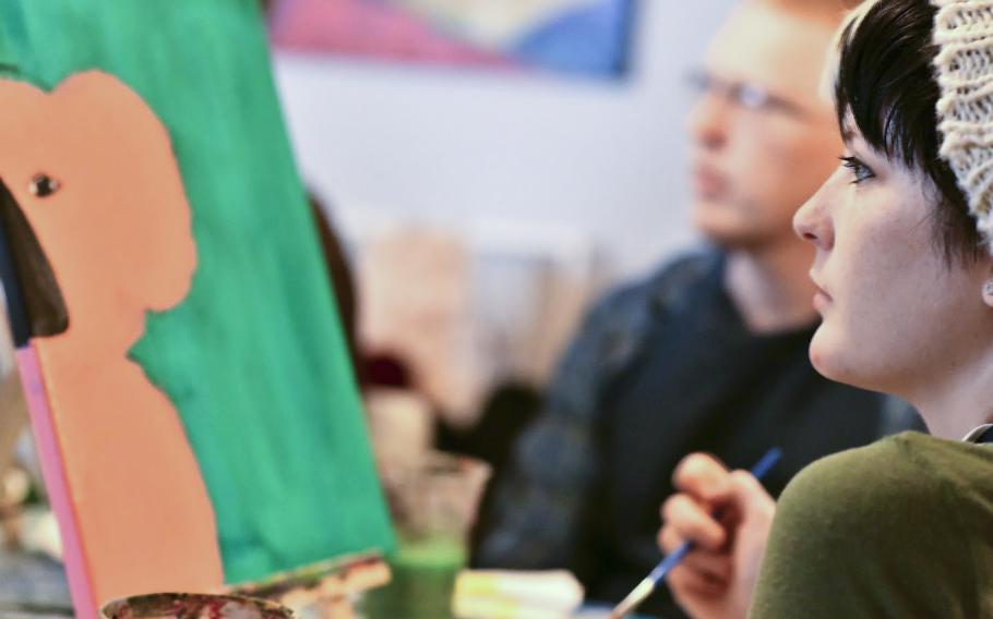 Michaela Olthoff of Great Falls, Mont., looks at the koala bear head she's painting at a charity event in Landstuhl, Germany, on Saturday, Jan. 25, 2020. Olthoff and 15 other amateur painters raised more than $600 at the painting event for victims of the Australian bushfires.
