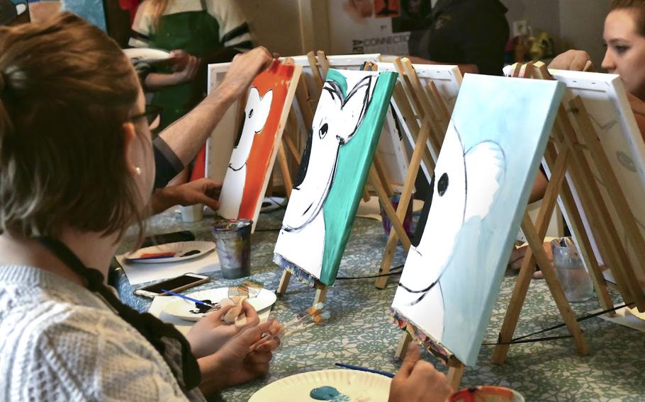 Nancy Brothers, left, and other amateur painters add colored backgrounds to the koala bear shapes they painted on Saturday, Jan. 25, 2020 at artist Beatrice Gentry's studio in Landstuhl, Germany. Sixteen members of the Kaiserslautern military community paid around $40 each to paint koala bears as part of a fundraiser to help victims of the Australian bushfires.