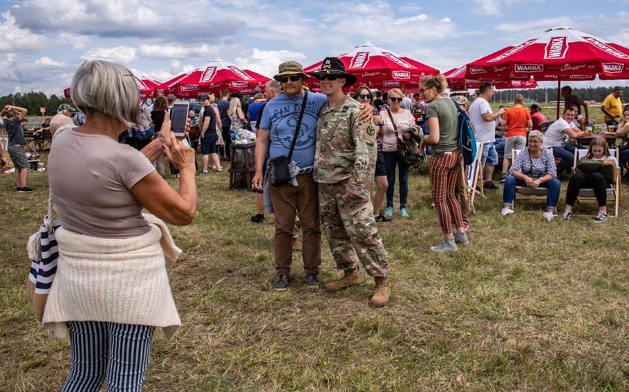 Cpt. Marc Speciale, 278th Armored Cavalry Regiment deployed with Battle Group Poland poses for pictures with locals during the "Tank Battle" event held at Bemowo Piskie Training Area, July 13.

Timothy Massey/U.S. Army