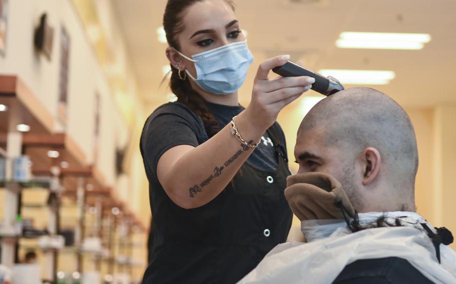 Kaltrian Ibrij shaves off Senior Airman Jeremiah Lamb's hair on Monday, May 4, 2020, on Ramstein Air Base, Germany. The base began reopening its haircut facilities after being closed for about six weeks due to the coronavirus pandemic.