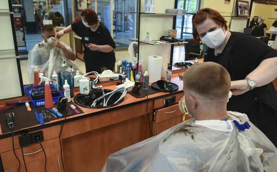 Stylist Claudia Oster finishes giving Staff Sgt. Kyle Knupp a haircut on Monday, May 4, 2020, at Ramstein Air Base, Germany. Barbershops on base opened up for the first time in about six weeks but must follow safety measures due to the coronavirus pandemic. 
