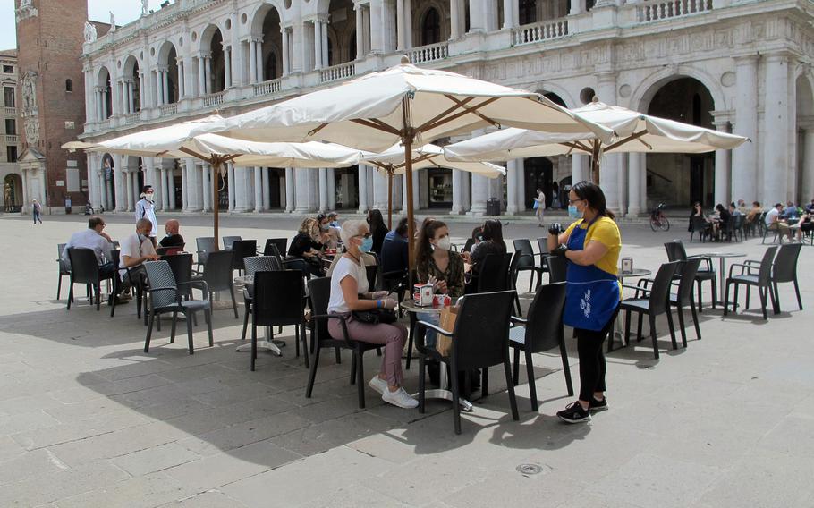 Italians in Vicenza's main piazza place their coffee orders on Monday, May 18, 2020, after Italy lifted some restrictions put in place in March because of the coronavirus. Troops with U.S. Army Garrison Italy remained prohibited from visiting cafes, except for takeout orders.

