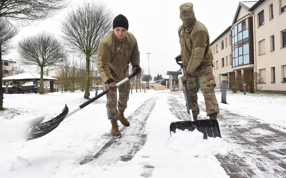 Airmen 1st Class David Camargo, 24, left, and Raylan Sherwood, 21, shovel snow outside their dormitory at Ramstein Air Base, Germany, on Tuesday, Dec. 1, 2020. It was the first snowfall of the season for military bases in the Kaiserslautern area. 
