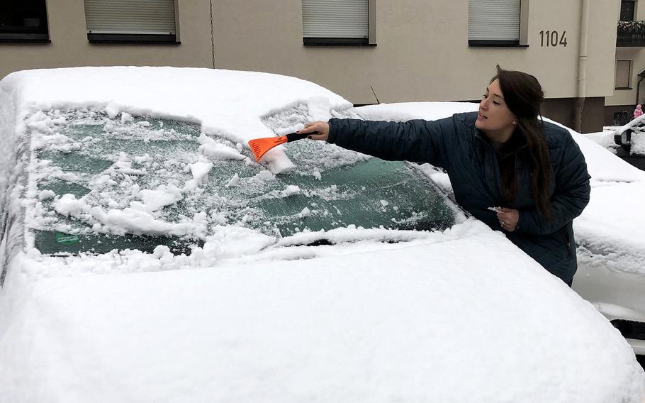 Sadie Webb scrapes the snow and ice off the windshield of her Chrysler Pacifica before heading to the post office at Ramstein Air Base, Germany,  Dec. 1, 2020. 
