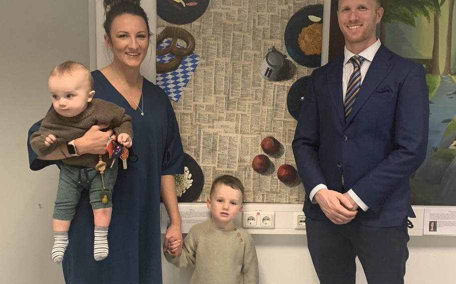 Jenn Clark, an art teacher for the kids' club at Hohenfels Training Area in Germany, poses with her two children, Quincy and Jackson, and husband Capt. Zachariah Clark, at the art exhibition at the base's acute respiratory center, Dec. 6, 2020. The exhibition aims to take patients' minds off the discomforts of being tested for the virus.

