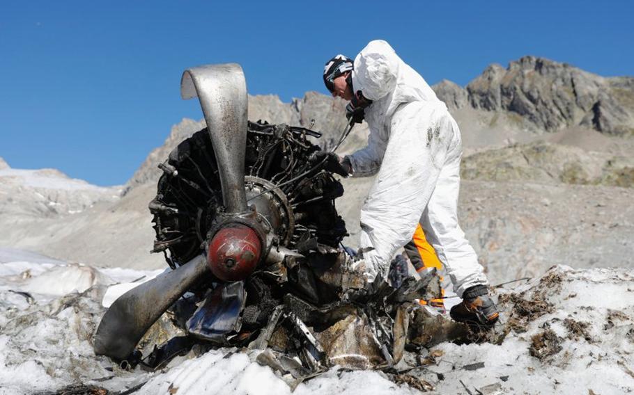 A Swiss soldier works on an engine of a U.S. C-53 Skytrooper that emerged from the ice of the Gauli Glacier in Switzerland in 2018, more than 70 years after the plane crash-landed at the top of the glacier in Nov. 1946. Analysis of ice samples collected from the glacier in 2019 led a scientist to update predictions of where and when the plane's fuselage will emerge from the ice.