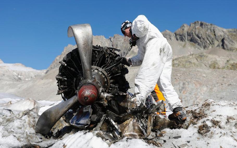 A Swiss soldier works on an engine of a U.S. C-53 Skytrooper that emerged from the ice of the Gauli Glacier in Switzerland in 2018, more than 70 years after the plane crash-landed at the top of the glacier in Nov. 1946. Analysis of ice samples collected from the glacier in 2019 led a scientist to update predictions of where and when the plane's fuselage will emerge from the ice.

