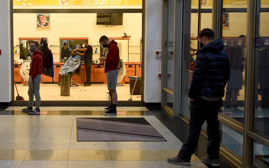 A line forms outside the barbershop at the Kaiserslautern Military Community Center on Ramstein Air Base, Germany, on Tuesday, Dec. 15, 2020, a day before strict new coronavirus restrictions were to go in effect in Germany. Under the new rules, hairdressers are among businesses set to close until at least Jan. 10, to try to bring down the number of infections in Germany.