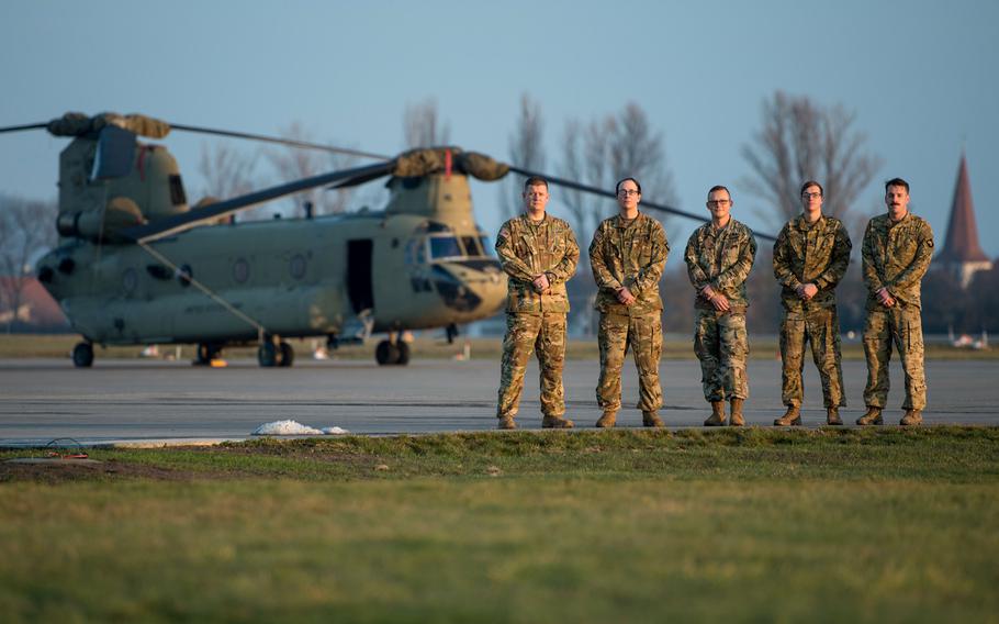 U.S. Army pilot Chief Warrant Officer 2 Dave Acton, flight engineer Sgt. Patrick Carter, medical officer Maj. Benjamin Stork, crew chief Spc. Bruce Cook and pilot Chief Warrant Officer 2 Robert Riedel, of Company B, 6th General Support Aviation Battalion, 101st Combat Aviation Brigade, 101st Airborne Division (Air Assault), stand in front of a CH-47F Chinook helicopter at Storck Barracks in Illesheim, Germany, Dec. 16, 2020. The crew landed in a field to provide medical aid to a car accident victim while on the way back from a training mission, Dec. 15, 2020.