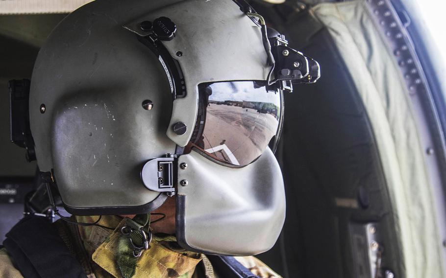 In a May 27, 2020 photo, a crew member with the 1st Combat Aviation Brigade, 1st Infantry Division, looks out the side of an HH-60 Blackhawk, May 27, at Fort Riley, Kan.