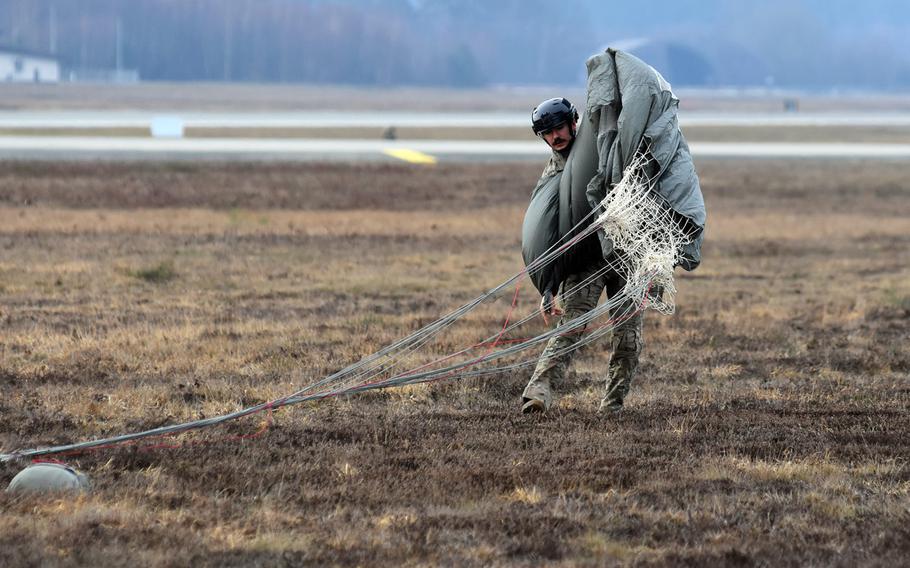 Tech. Sgt. Dwight Stalter of the 435th Contingency Response Group at Ramstein Air Base, Germany, folds his parachute after landing at the base's airfield on Thursday, Feb. 18, 2021.
