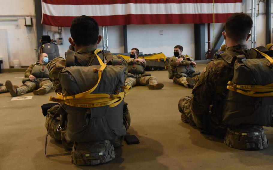 Paratroopers sit with their gear inside a hangar at Ramstein Air Base, Germany, before a jump on Feb. 18, 2021. About 30 paratroopers from Army and Air Force units in Germany had the rare chance to jump at Ramstein's busy airfield to maintain their jump requirements. 
