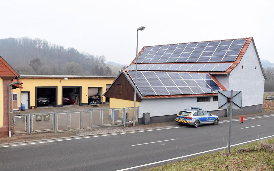 A police car is parked outside a home on the outskirts of Weilerbach, Germany, Wednesday, March 10, 2021, at the scene of what is believed to be a double homicide. Police are still searching for a suspect. Several officers could be seen walking around the back side of the property Wednesday.
