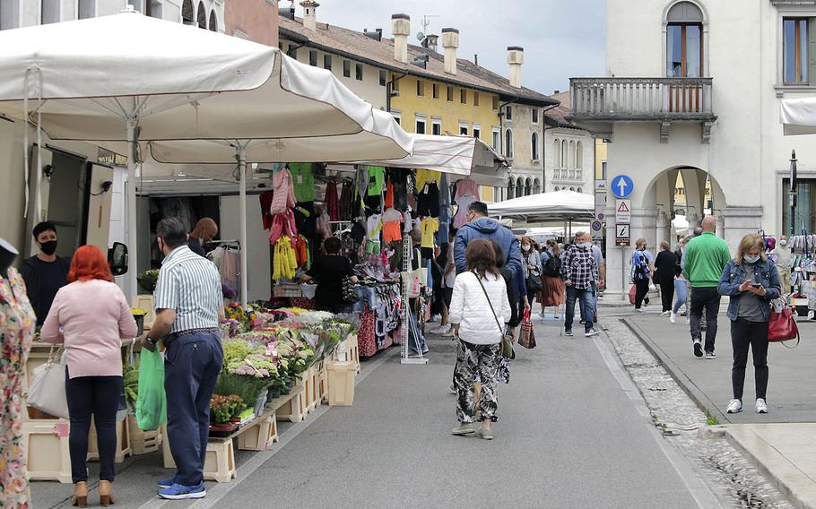 Shoppers do business at an open-air market in the town of Sacile, Italy, about 9 miles from Aviano Air Base. The region that includes Aviano is among  a dozen containing about two thirds of Italy's population that will be considered red zones Monday as the country's battle with the coronavirus intensifies. 